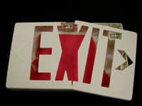 A plastic exit sign that has been broken into pieces.
